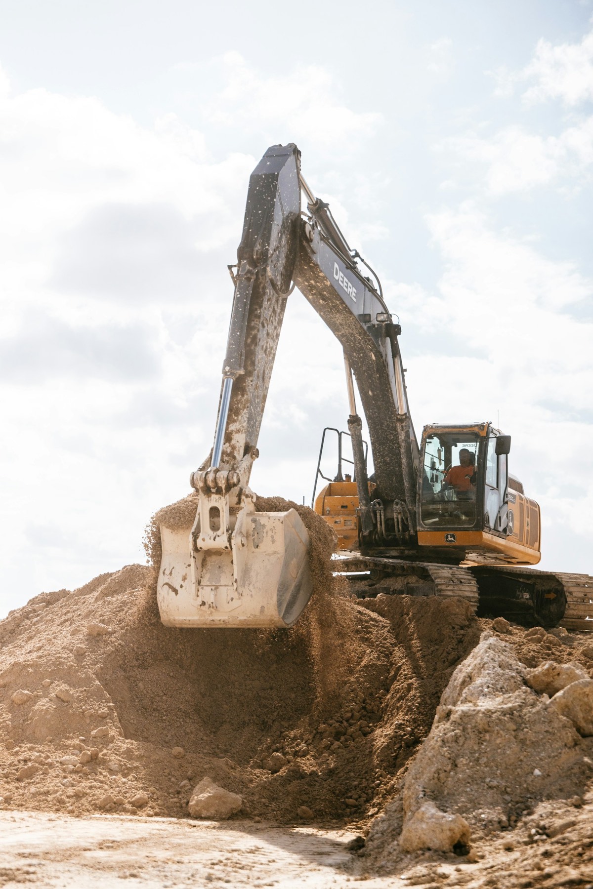 Kettenbagger schüttet mit der Schaufel Erdreich auf einer Baustelle ab
